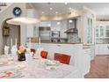 Bright eat-in kitchen with white cabinets, stainless steel appliances, a center island, and stone countertops at 512 77Th St, Holmes Beach, FL 34217