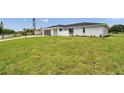 Side view of a well-maintained single-story home with a lush green lawn at 5125 Palm Aire Dr, Sarasota, FL 34243