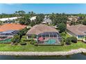 An aerial view of the rear exterior featuring a screened-in pool, a serene pond, and well-manicured landscaping at 5205 88Th E St, Bradenton, FL 34211