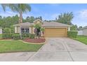 Charming home featuring a manicured lawn, mature landscaping, and a two-car garage at 5618 Sheer Bliss Loop, Land O Lakes, FL 34639