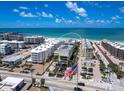 Gorgeous aerial view of the beachfront condominium with an American flag in the foreground at 6512 Midnight Pass Rd # 301, Sarasota, FL 34242