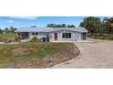 Home exterior displaying metal roof, vibrant orange door, and tidy lawn at 7160 Myakka Valley Trl, Sarasota, FL 34241