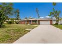 Well-maintained, one-story brick home with lush landscaping and a long driveway leading to the garage at 7803 2Nd W Ave, Bradenton, FL 34209