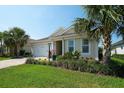 Charming single-story home with a paver driveway, lush lawn, and manicured tropical landscaping at 8077 Sandstar Way, Sarasota, FL 34240