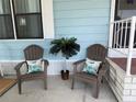 Inviting front porch with two chairs and a decorative palm tree, creating a cozy outdoor seating area at 8531 Imperial Cir, Palmetto, FL 34221