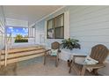 Relaxing covered porch featuring two Adirondack chairs with decorative pillows and decorative palm at 8531 Imperial Cir, Palmetto, FL 34221