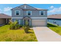 Two-story home with a blue exterior, light shutters, a two-car garage, and a well-manicured lawn at 8656 40Th E Cir, Palmetto, FL 34221