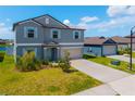 Two-story home with a blue exterior, light shutters, a two-car garage, and a well-manicured lawn at 8656 40Th E Cir, Palmetto, FL 34221