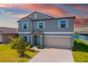 Two-story home with a blue exterior, light shutters, a two-car garage, and a well-manicured lawn at 8656 40Th E Cir, Palmetto, FL 34221