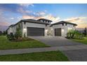 Elegant home featuring a paved driveway leading to a spacious three-car garage, enhancing curb appeal at 8982 Baroque Ter, Sarasota, FL 34240