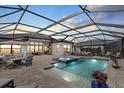 This screened-in pool area features a hot tub, plenty of seating, and an outdoor eating area at 8982 Baroque Ter, Sarasota, FL 34240