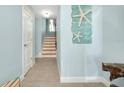 Hallway with decorative starfish and beach-themed decor leading to staircase at 1001 Point Of Rocks Rd # 207, Sarasota, FL 34242