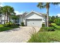 Lovely single-story home features a tile roof, two-car garage, paver driveway, and lush tropical landscaping at 11502 Golden Bay Pl, Bradenton, FL 34211