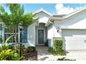 Inviting entryway features a decorative glass door, blue shutters, and professionally landscaped flower beds at 11502 Golden Bay Pl, Bradenton, FL 34211