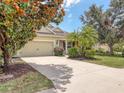 Inviting single-story home with lush landscaping, mature trees, and a paved driveway leading to an attached garage at 11714 Forest Park Cir, Bradenton, FL 34211