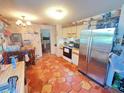 Galley kitchen featuring stainless steel appliances, unique countertops, and tiled floors at 12127 Hunter Ave, Port Charlotte, FL 33953