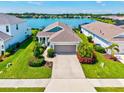 An inviting single-story home boasts lush landscaping, a two-car garage, and beautiful water views at 13849 Old Creek Ct, Parrish, FL 34219