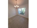 Bright dining room featuring tile floors, decorative chandelier, and window offering natural light at 1422 Jakway Rd, North Port, FL 34288