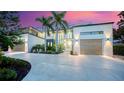 Stunning modern home showcasing lush landscaping, palm trees, and a spacious driveway at 1607 Flower Dr, Sarasota, FL 34239