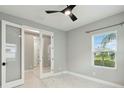 Bright bedroom with marble floors, neutral paint, large window, and a stylish ceiling fan at 2794 Butterfly Jasmine Trl, Sarasota, FL 34240