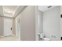 Bright powder room featuring neutral walls, white trim, and a toilet with modern fixtures next to the entryway at 2794 Butterfly Jasmine Trl, Sarasota, FL 34240