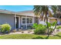 Close up of the home's front entry, emphasizing lush tropical landscaping, a cozy bench, and a welcoming doorway at 2801 21St W Ave, Bradenton, FL 34205