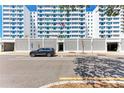 Apartment entrance featuring a light gray car parked out front, a textured white fence and a flagpole at 33 S Gulfstream Ave # 306, Sarasota, FL 34236