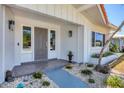 Inviting front entrance with a gray door, stone walkway, and well-maintained landscaping at 3426 Brookline Dr, Sarasota, FL 34239