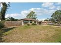 Inviting home with a fenced front yard, mature trees, and a classic suburban street view at 3881 Holin Ln, North Port, FL 34287