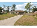 Single-Gathering home with an attached garage and a long driveway, surrounded by mature trees at 3881 Holin Ln, North Port, FL 34287