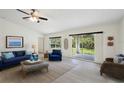 Bright living room with stylish furniture, light wood floors and sliding glass doors to the yard at 4091 Dull St, North Port, FL 34286