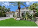 Charming two-story home with a three-car garage, tiled roof, and tropical landscaping at 4108 Roberts Point Rd, Sarasota, FL 34242