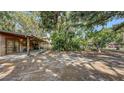 Wood-sided home with covered patio offers views of lush wooded backyard at 4122 Old Bradenton Rd, Sarasota, FL 34234