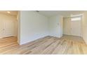 Spacious, bright empty room with wood flooring and a white entry door at 4206 Park Willow Ave, Palmetto, FL 34221