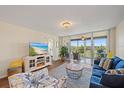 Cozy living room area with a view to the balcony, a couch, and stylish coastal decorations at 4570 Pinebrook Cir # 508, Bradenton, FL 34209