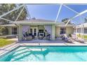 Relaxing backyard oasis featuring a screened-in patio, inground pool, and comfortable seating area at 4758 Breezy Pines Blvd, Sarasota, FL 34232