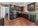 Well-equipped kitchen featuring dark cabinets, stainless steel appliances, and hardwood flooring at 4758 Breezy Pines Blvd, Sarasota, FL 34232