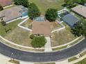 Aerial view of home with a screened pool, surrounded by a white fence and lush greenery at 4951 Brightstone Pl, Spring Hill, FL 34609