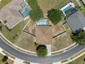 Overhead view of home with a screened-in pool, neat landscaping, and circular driveway at 4951 Brightstone Pl, Spring Hill, FL 34609