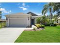 Beautiful single-story home boasts a lush green lawn, attached garage, and appealing exterior at 5020 Torrey Pines Run, Bradenton, FL 34211