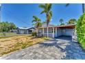 Charming home featuring a light blue exterior, covered parking, and a neatly bricked driveway at 513 25Th W Ave, Bradenton, FL 34205