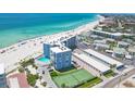 Aerial view of a beachfront condominium featuring pool, tennis court, and stunning ocean views at 5300 Gulf Dr # 501, Holmes Beach, FL 34217
