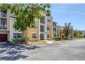 View of the yellow condo building featuring an open balcony space at 5552 Bentgrass Dr # 7-301, Sarasota, FL 34235