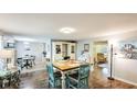 Bright dining area features a wood table, modern lighting, wood floors, and access to other rooms at 5603 1St Avenue Dr Nw, Bradenton, FL 34209
