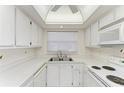 Efficient kitchen with white cabinets, a window, and essential appliances for meal preparation at 6030 7Th W Ave # 6030, Bradenton, FL 34209