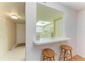 Bright kitchen view featuring a breakfast bar with seating and a glimpse into the adjacent spaces at 6030 7Th W Ave # 6030, Bradenton, FL 34209