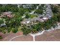 An aerial view of townhomes with golf course frontage and mature trees in a lush golf course community at 6110 Country Club Way # 102, Sarasota, FL 34243