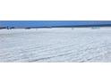 Wide, sandy beach with scattered umbrellas and beachgoers, showing a popular spot for relaxation and recreation at 6150 Midnight Pass Rd # V4, Sarasota, FL 34242