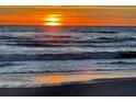 Beautiful beach sunset casting golden light on the ocean waves, creating a tranquil scene at 6150 Midnight Pass Rd # V4, Sarasota, FL 34242