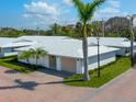 Beautiful home with white tile roof, tan garage door, manicured lawn, and brick paver driveway at 6300 Midnight Pass Rd # 5, Sarasota, FL 34242